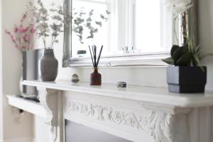a white console table with vases and a mirror at Seaways Apartment in Worthing +19 photos