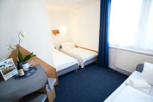 a hotel room with two beds and a table at Resort Kovács in Novosedly +32 photos