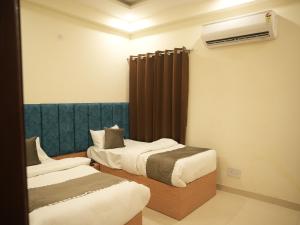 a hotel room with two beds and a radiator at The RaaS Guestline in Noida
