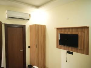 a hotel room with a tv and a door and a room at The RaaS Guestline in Noida