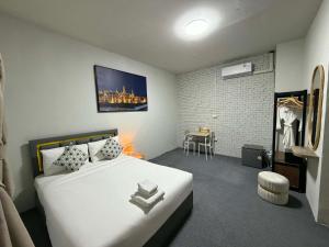 a bedroom with a large white bed and a table at Phuket gateway inn in Kathu