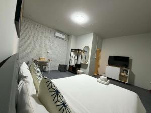 a bedroom with a large white bed and a tv at Phuket gateway inn in Kathu +27 photos