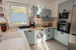 a kitchen with a washing machine and a microwave at Spacious appartment with terrace and shared pool in Fréjus
