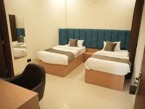 a room with two beds and a mirror at The RaaS Guestline in Noida +23 photos