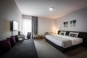 a hotel room with a large bed and a desk at Nobel Inn Hotel in Belgrade +35 photos
