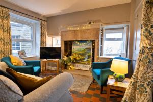 a living room with blue chairs and a fireplace at Finest Retreats - East Bank in Matlock