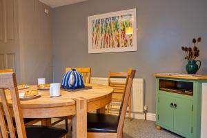a dining room with a wooden table and chairs at Finest Retreats - East Bank in Matlock
