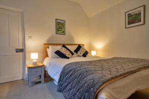 a bedroom with a bed and two lamps on a table at Finest Retreats - East Bank in Matlock