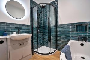 a bathroom with a shower and a sink and a tub at Finest Retreats - East Bank in Matlock +16 photos