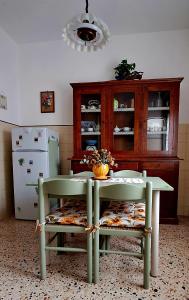 a kitchen with a table and two chairs and a refrigerator at Orlando House 1975 in Montecchio