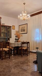 a dining room with a table and chairs and a chandelier at Orlando House 1975 in Montecchio