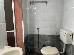 a bathroom with a toilet and a sink at The Redstones Resort in Malvan