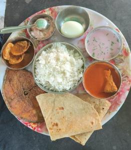 a plate of food with rice and other foods at The Redstones Resort in Malvan