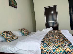 a bed with two pillows on it in a room at The Redstones Resort in Malvan
