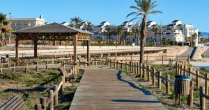 a wooden boardwalk leading to a gazebo at a beach at Alboran - RETAMAR EXPERIENCE in Almería
