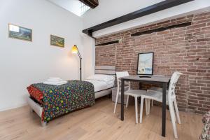 a bedroom with a bed and a table and a brick wall at Stay Bergamo Centro in Bergamo