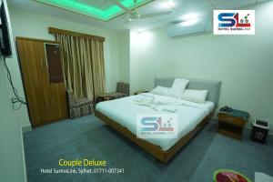 a bedroom with a bed with a sign on it at Hotel SurmaLink in Sylhet