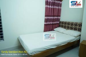 a bed in a room with a sign on it at Hotel SurmaLink in Sylhet