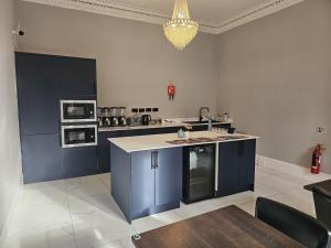 a large kitchen with blue cabinets and appliances at Edinburgh City Hotel in Edinburgh