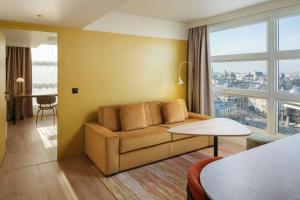a living room with a couch and a large window at Residence Inn by Marriott Lille in Lille +32 photos