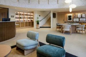 a lobby with two chairs and a table and stairs at Residence Inn by Marriott Lille in Lille