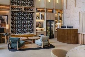 a lobby with chairs and tables and wine bottles at Residence Inn by Marriott Lille in Lille