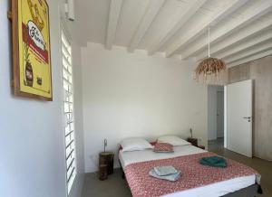 a bedroom with a bed in a white room at Villa Ever Blue in Le Vauclin