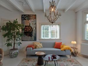 a living room with a couch and a chandelier at Ons Buiten in Bergen