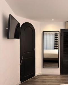 a bedroom with a black door and a mirror at Hotel B Lodge in Saint-Tropez