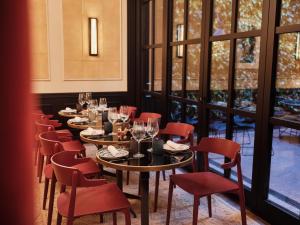 a row of tables and chairs in a room with windows at Wittmore Hotel GL- Adults Only, Small Luxury Hotels in Barcelona