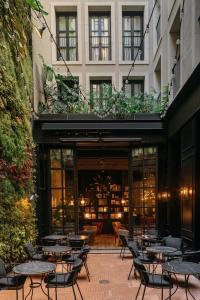 a patio with tables and chairs in front of a building at Wittmore Hotel GL- Adults Only, Small Luxury Hotels in Barcelona