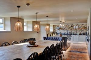a kitchen and dining room with a large wooden table and chairs at Finest Retreats - Blackton Farmhouse in Barnard Castle