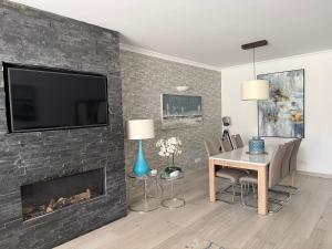 a living room with a fireplace with a tv on a brick wall at Vila Sol, Apartment 468 in Quarteira