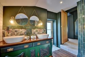 a bathroom with two sinks and two mirrors at Finest Retreats - Blackton Farmhouse in Barnard Castle +42 photos