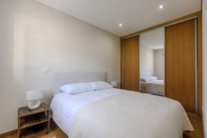 a bedroom with a large white bed and a mirror at Casa das Agras in Souto +27 photos