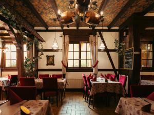 a restaurant with tables and chairs in a room at Hotel Restaurant Au Parc des Cigognes in Kintzheim