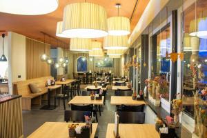 a restaurant with tables and chairs and chandeliers at 5 room apartment for 8 people at Bergcafe Aurora Lenzerheide in Lenzerheide