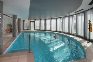 a person in a swimming pool in a building at DOMITYS SARIA in Serris