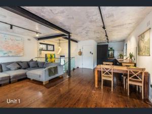 a living room with a couch and a table at A spacious Family Retreat near the Beach in Cronulla