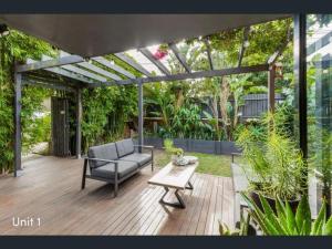 a patio with a couch and a table at A spacious Family Retreat near the Beach in Cronulla