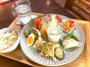 a tray with two plates of food on a table at ゲストハウスきーず in Nishio