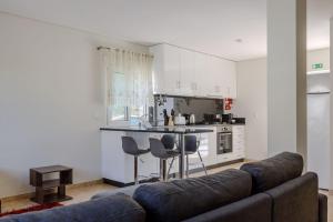 a living room with a couch and a kitchen at Casa das Agras in Souto