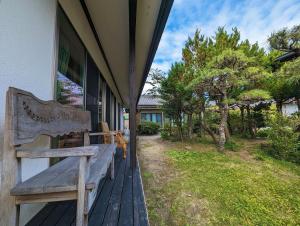 a wooden bench sitting on the porch of a house at ゲストハウスきーず in Nishio