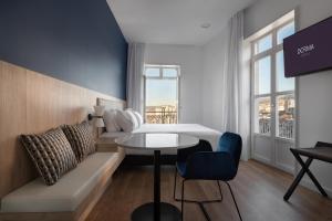 a hotel room with a bed and a table and a couch at Dorma Vigo in Vigo