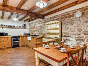 a kitchen with a wooden table and a stone wall at 2 Bed in Nottingham oc-47032 in Besthorpe +10 photos