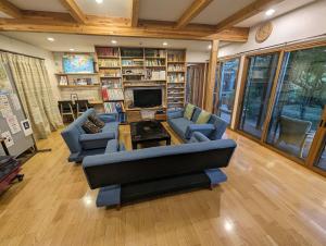 a living room with a couch and chairs and a fireplace at ゲストハウスきーず in Nishio
