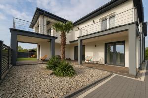 a house with a palm tree in front of it at Eden Apartament-Jacuzzi, sauna in Jastrzębia Góra