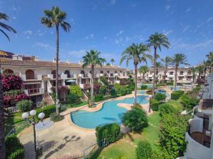 an aerial view of a resort with a swimming pool and palm trees at Beachfront in Denia Alicante in Denia