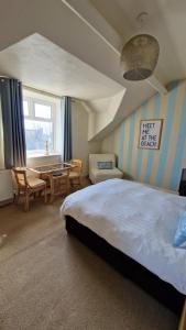 a bedroom with a bed and a table and a window at Black Sheep Lodge in Holyhead