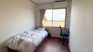 a bedroom with a bed and a desk and a window at Sane Yanagisawa in Awaji